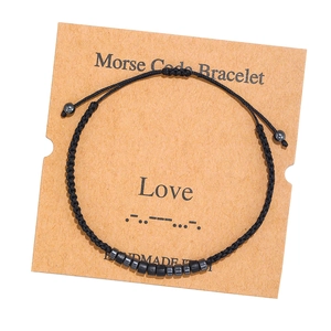 Detailed view of handmade Morse Code bracelet with Love theme on a kraft paper card