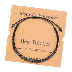 Close-up of handmade Morse code bracelet with black beads on a kraft paper card