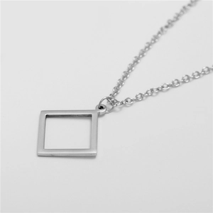 Detail view of the hollow square geometric pendant and sleek stainless steel chain