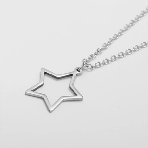 Macro shot of silver hollow star pendant with polished finish on sleek link chain