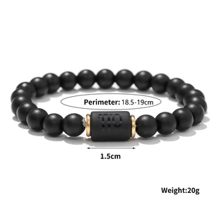Close-up of matte black onyx beads with a Virgo zodiac sign and golden spacers