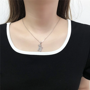 Zilveren ketting met kroonletter N en zirkoon hanger gedragen door een model