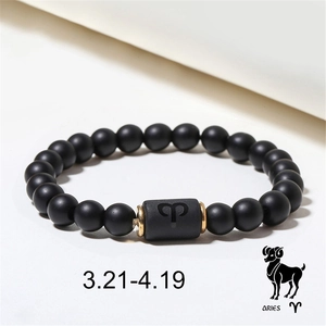 Macro detail of Aries zodiac bead bracelet with black onyx stones and golden spacers