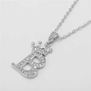 Macro detail of silver crown pendant with letter B encrusted in cubic zirconia