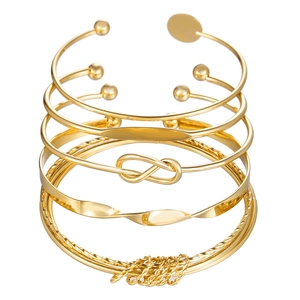 Dettaglio del set di bracciali bohémien in oro con charm infinito e motivi metallici intrecciati