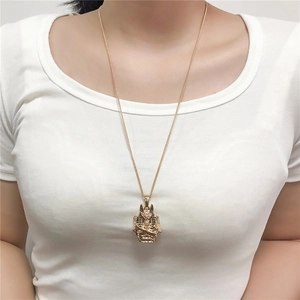 Detailed view of long gold necklace with Ancient Egyptian Pharaoh pendant on a model