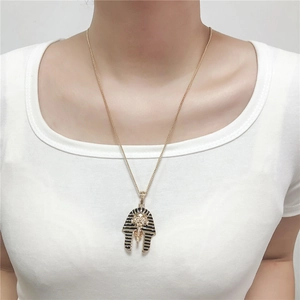 Detail of Egyptian pharaoh pendant necklace worn by model on a white shirt
