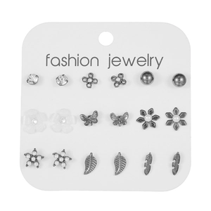 Detalle de set de 9 pares de pendientes con perlas y motivos de mariposa en cartón