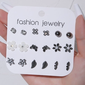 Detalle de 9 pares de pendientes con flores de perlas, mariposas negras y motivos de hojas
