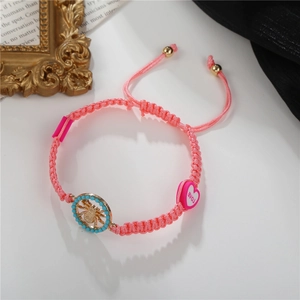 Adjustable pink woven bracelet featuring a golden spider charm and blue beaded accents