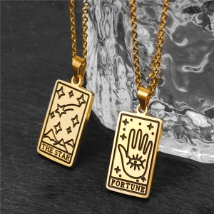 Vue macro de pendentifs tarot dorés montrant les détails gravés de l'Étoile et Fortune