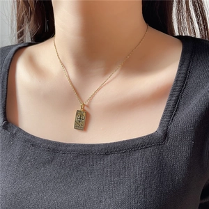 Collier avec pendentif Tarot Le Monde en acier titane doré porté par un modèle