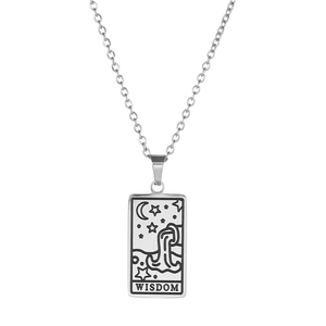 Gros plan du pendentif tarot argenté avec lune et étoiles et texte gravé Wisdom