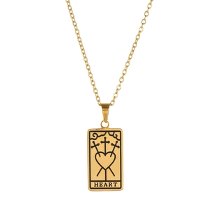 Détail du pendentif tarot doré avec motif de cœur, épées croisées et texte gravé