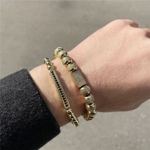 Nahaufnahme von Herren-Kronenarmbändern mit Goldperlen und schwarzen Zirkonia