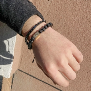 Nahaufnahme der Herren-Perlenarmbänder mit Goldzirkon-Barren und schwarzem Metallanhänger