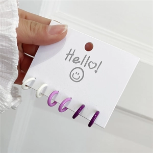 Set mit sechs Mini-Emaille-Creolen in Weiß- und Violetttönen auf Display-Karte