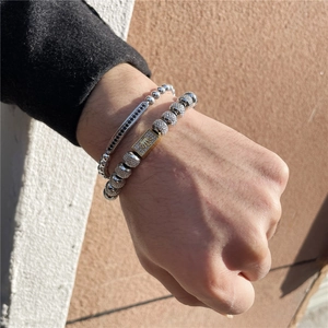 Detail eines gewebten Kronenarmbands für Herren mit Silberperlen und Zirkonia