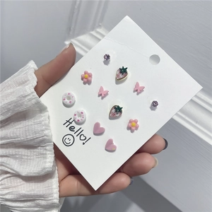 Detail eines süßen Ohrring-Sets mit Erdbeer-, Blumen- und Herzmotiven für Damen