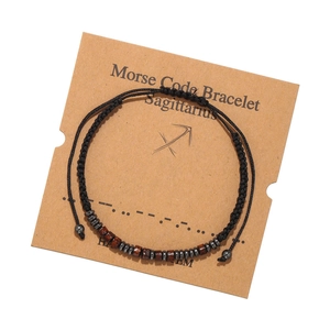 Bracelet Sagittaire code Morse avec cordon noir et perles en bois sur carte