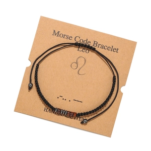 Détail du bracelet code Morse Lion fait main avec perles bois sur une carte