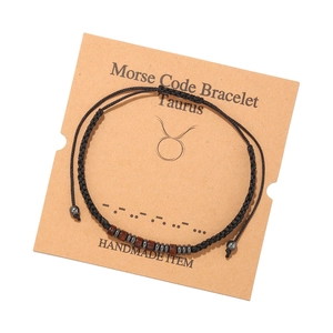 Détail du bracelet fait main Taurus code Morse avec perles de bois sur carte