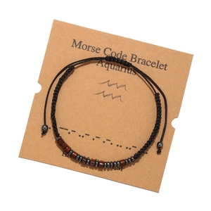 Détail du bracelet Verseau en code Morse avec perles de bois sur carte de présentation