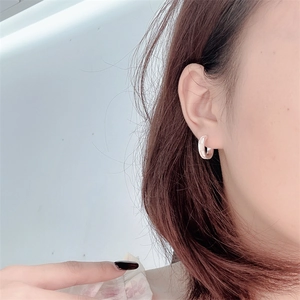 Nahaufnahme eines S925 Silber-Ohrrings mit weißem Perlmutt-Inlay an einem Modellohr getragen