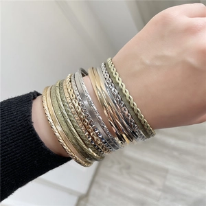 Set van 16 gemengde metalen armbanden in goud, zilver en brons om de pols van het model