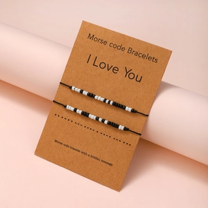 Morse code couple bracelets with black beads on a card holder for lovers