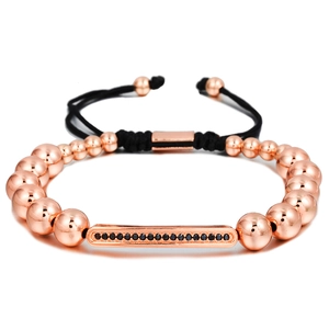 Macro shot of rose gold bead bracelet with zircon bar and black braided cord