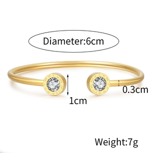 Detalle del brazalete de acero inoxidable dorado con números romanos y circonita