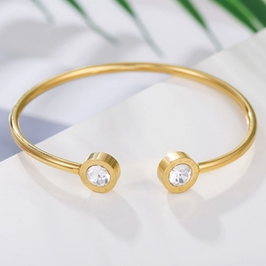 Detalle del brazalete dorado con números romanos y piedras de circonio brillantes