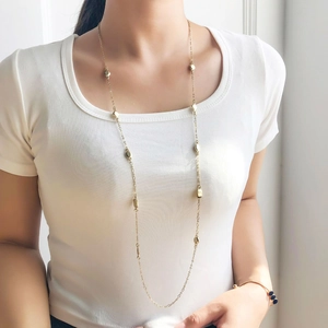 Elegante collar de cadena dorada con cuentas geométricas y pulsera de piedra azul