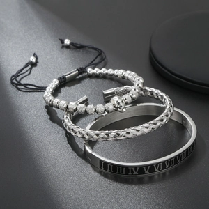 Dettaglio set di bracciali in acciaio argento con teschio e numeri romani intrecciati