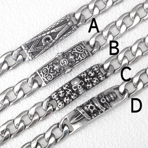 Dettaglio macro di bracciali punk teschio con finitura argento antico e maglie a catena cubana