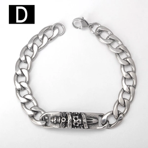 Dettaglio del bracciale a catena cubana in acciaio con incisione di teschio e pugnale