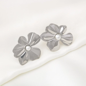 Elegant silver stainless steel flower earrings with white pearl center on silk background