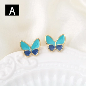 Elegantes pendientes de mariposa dorados con esmalte azul en base de cerámica