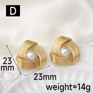 Detail of 23mm spiral gold earrings with white pearl inlay on silk background