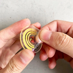Acrylic rainbow apple teacher keychain with protective film being peeled off