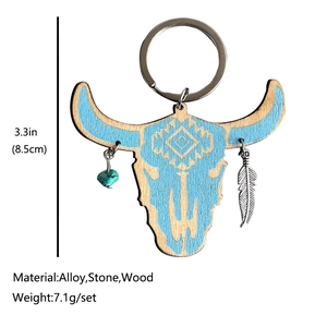 Western bull skull wooden keychain with turquoise and feather charms on white background