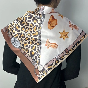 Détail d'un foulard en soie avec motif léopard, bottes de cowboy et insigne de shérif