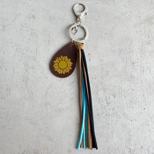 Detail of crazy horse leather keychain with sunflower pendant and colorful tassels