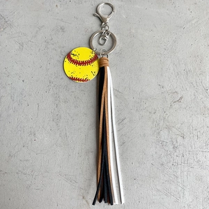 Detail of sports keychain showing softball charm and multi-color leather tassels hanging