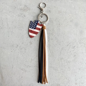 Detail of USA flag arrow pendant with multi-color leather tassels and silver keyring