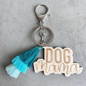 Détail d'un porte-clés en bois fait main avec pompons bleus et gravure DOG mama