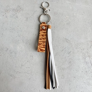 Handmade brown leather keychain with vintage embossed strip and colorful tassels