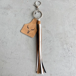 Porte-clés style western en daim avec pendentif tête de taureau et franges en cuir