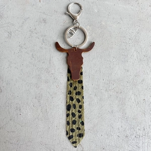 Detail of western cow skull leather keychain with leopard print tassel and metal clasp